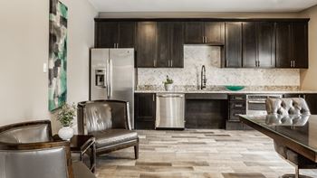 A modern kitchen with dark wood cabinets and a marble backsplash.